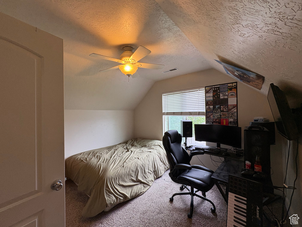 Carpeted bedroom featuring lofted ceiling, a textured ceiling, a desk, and ceiling fan