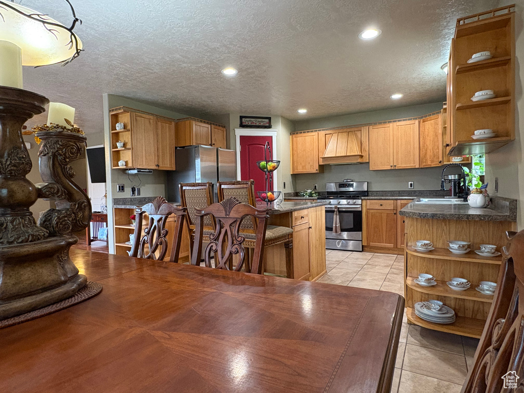 Kitchen featuring open shelves, stainless steel appliances, custom exhaust hood, recessed lighting, and dark countertops