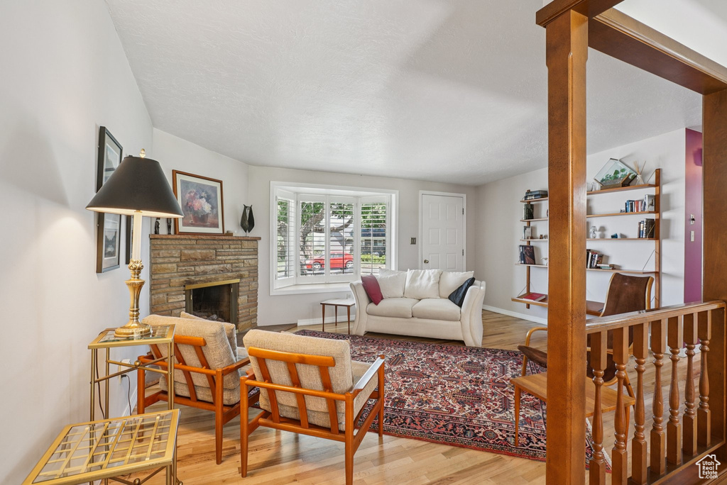 Living room with wood finished floors and a stone fireplace