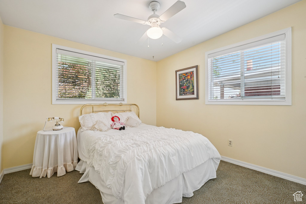 Carpeted bedroom with baseboards and a ceiling fan
