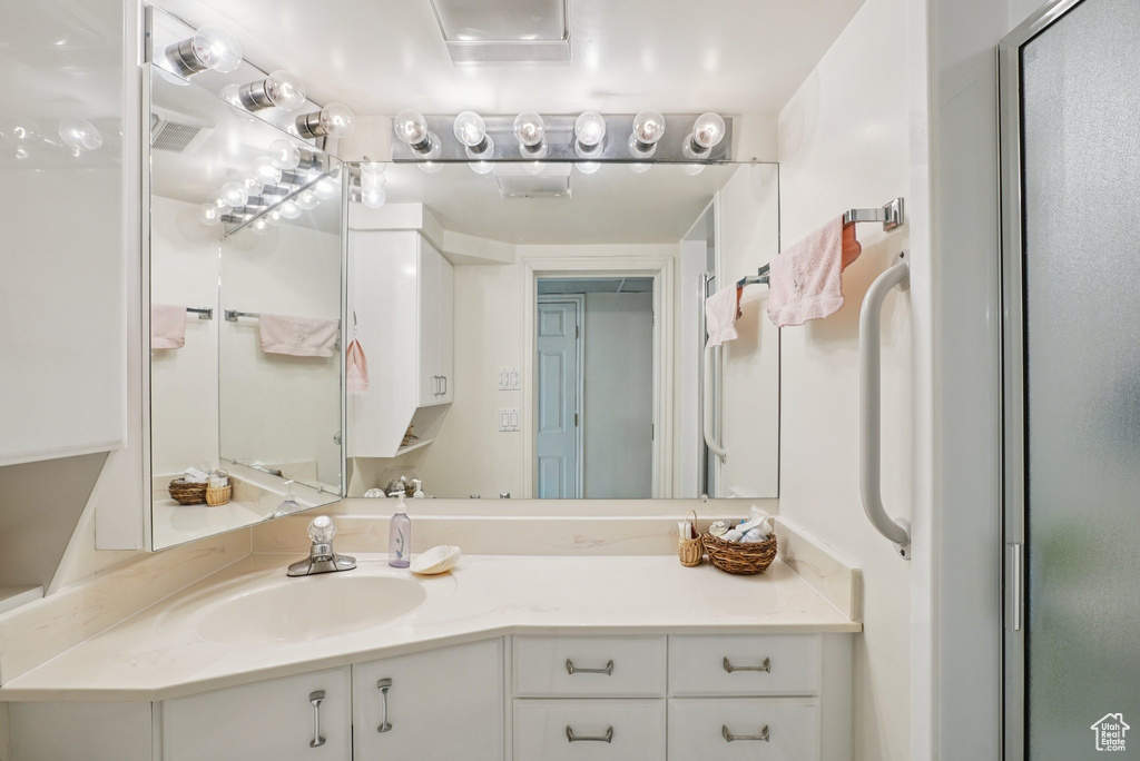 Full bath with vanity and a shower with shower door