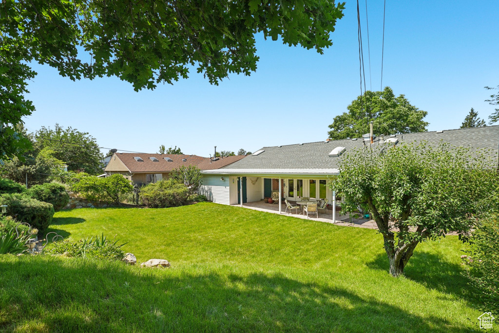 Back of property featuring a patio area and a yard