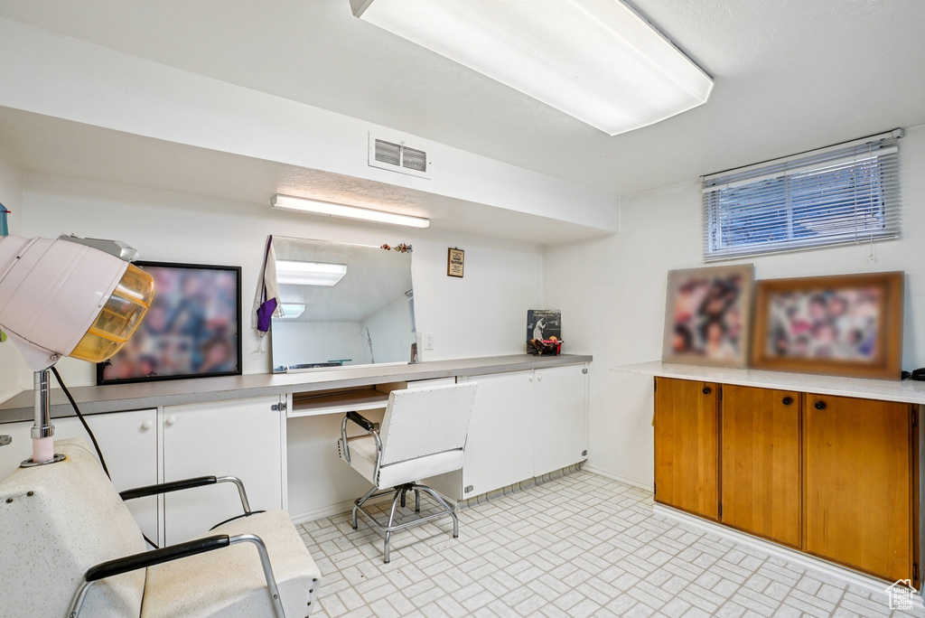 Home office featuring brick patterned flooring and baseboards