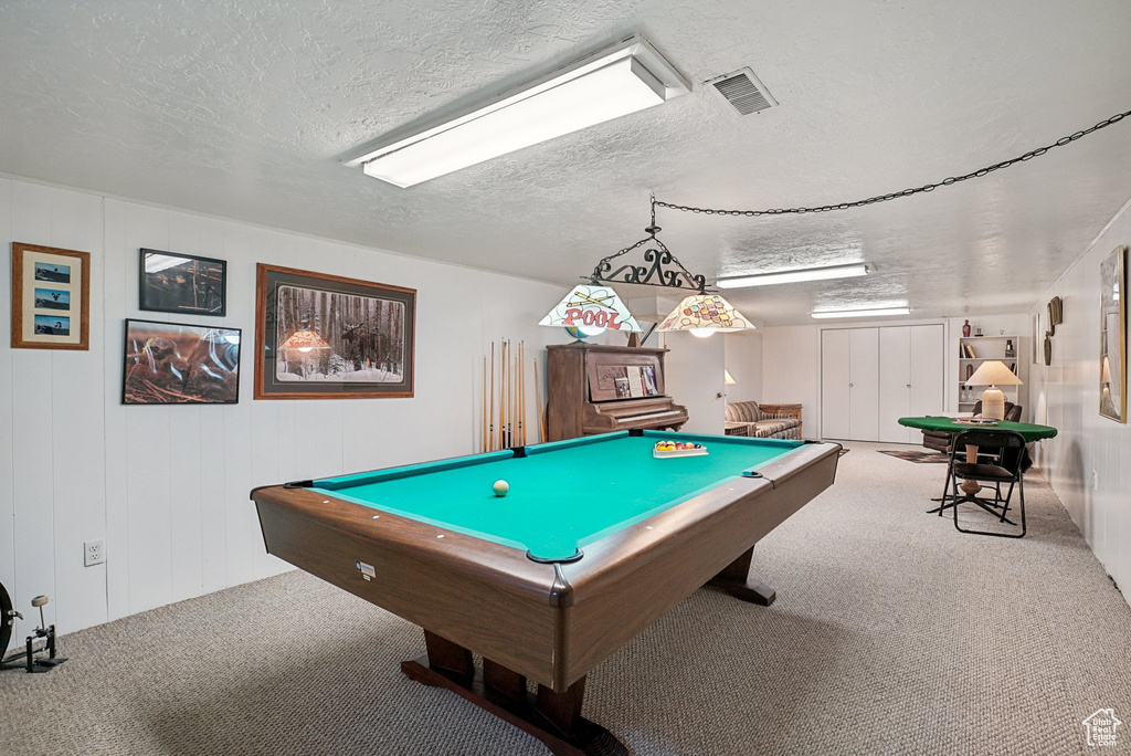 Game room with carpet floors, a textured ceiling, and pool table