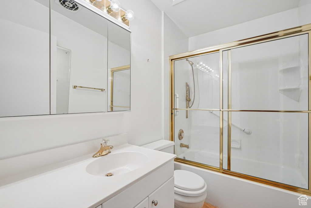Full bathroom featuring vanity and bath / shower combo with glass door