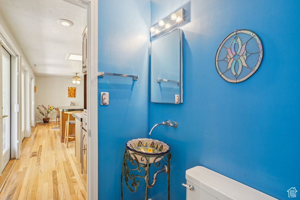 Half bathroom featuring toilet and wood finished floors