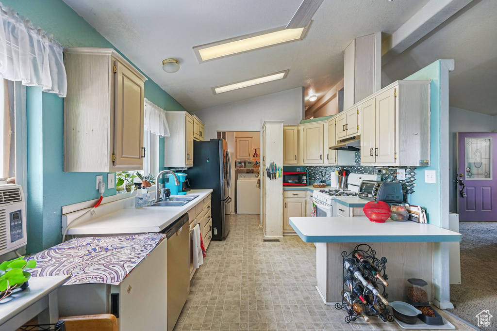 Kitchen with white range with gas cooktop, under cabinet range hood, stainless steel dishwasher, vaulted ceiling, and light countertops