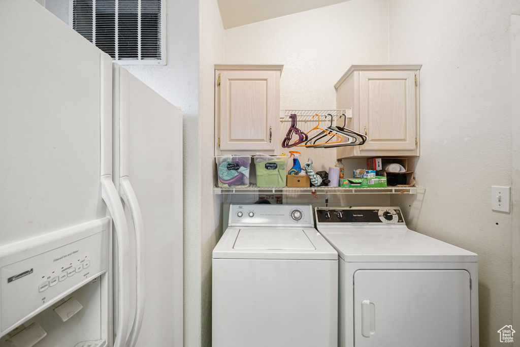 Washroom with cabinet space and washing machine and dryer