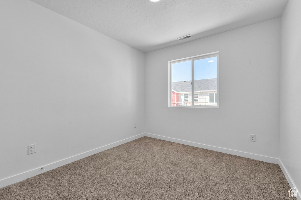 Carpeted spare room with baseboards