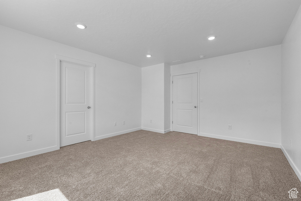 Carpeted empty room with recessed lighting