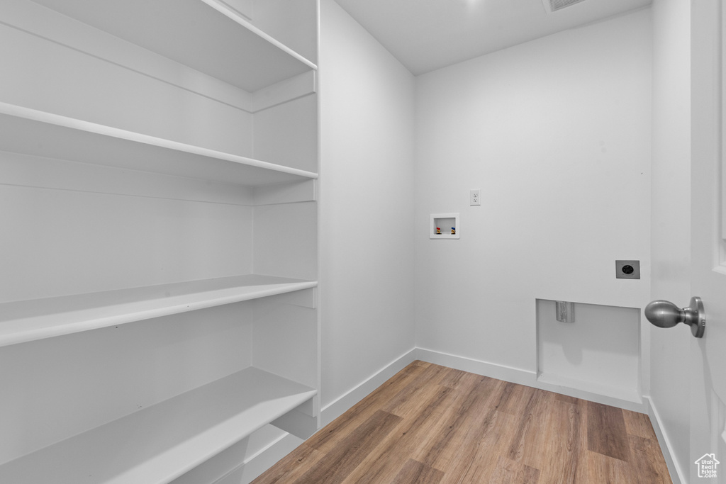Laundry area with electric dryer hookup, washer hookup, and wood finished floors