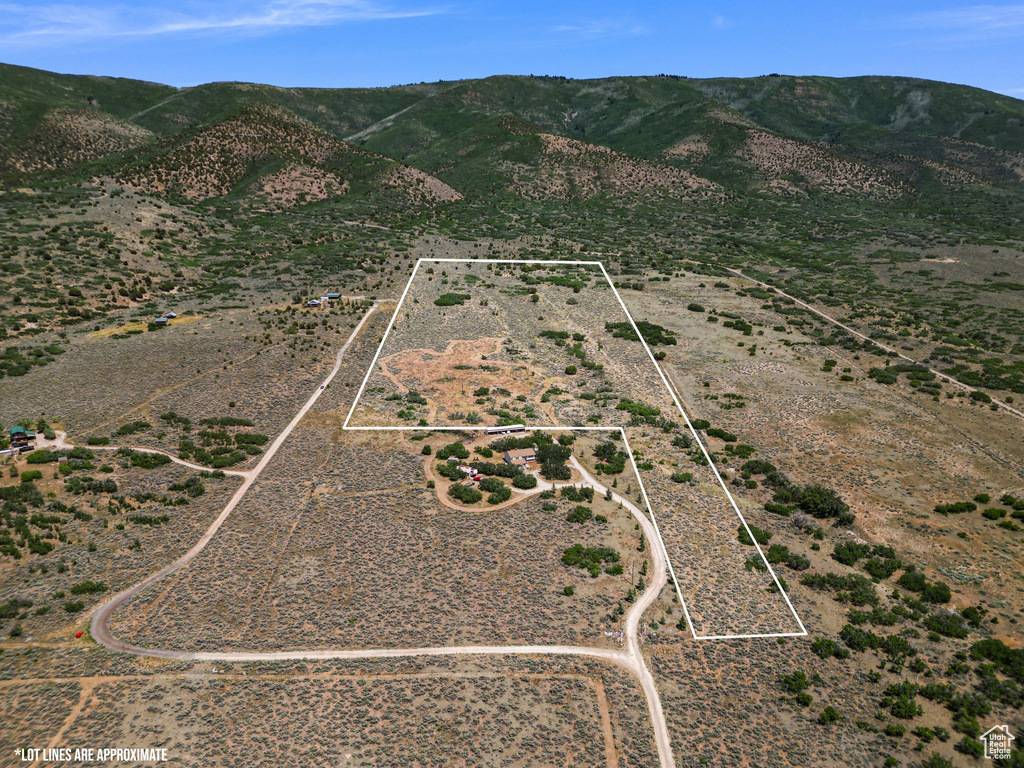 Aerial view of property\'s location with property boundaries highlighted, rural landscape, and a mountainous background