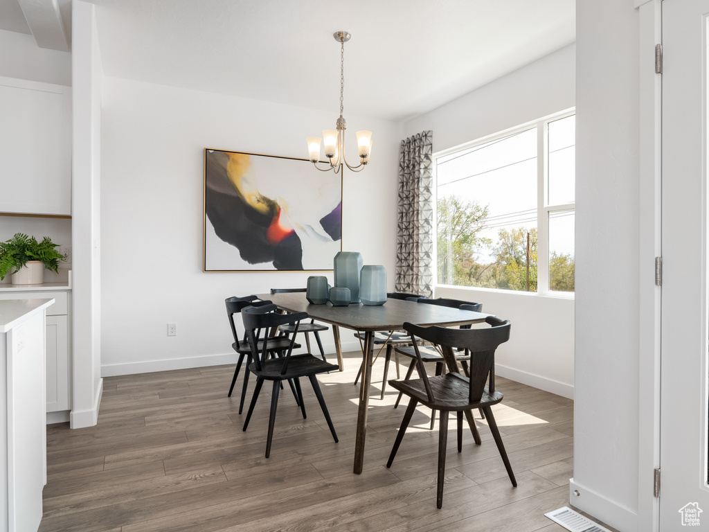 Dining area with a chandelier and wood finished floors