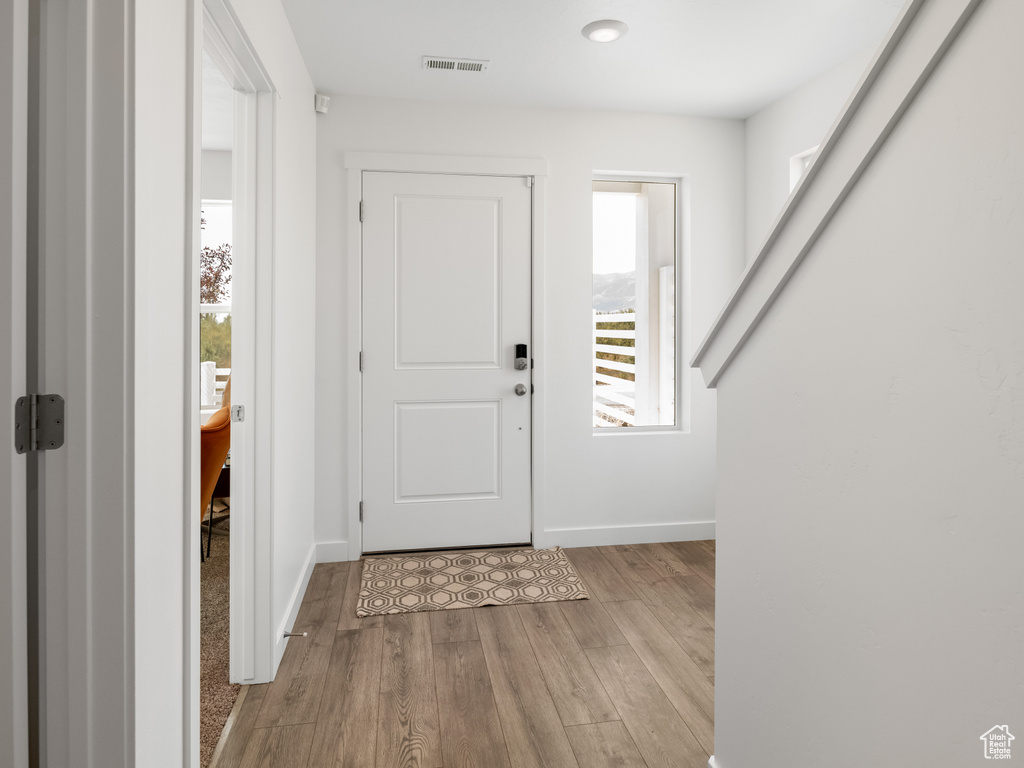 Entrance foyer featuring healthy amount of natural light, wood finished floors, and recessed lighting
