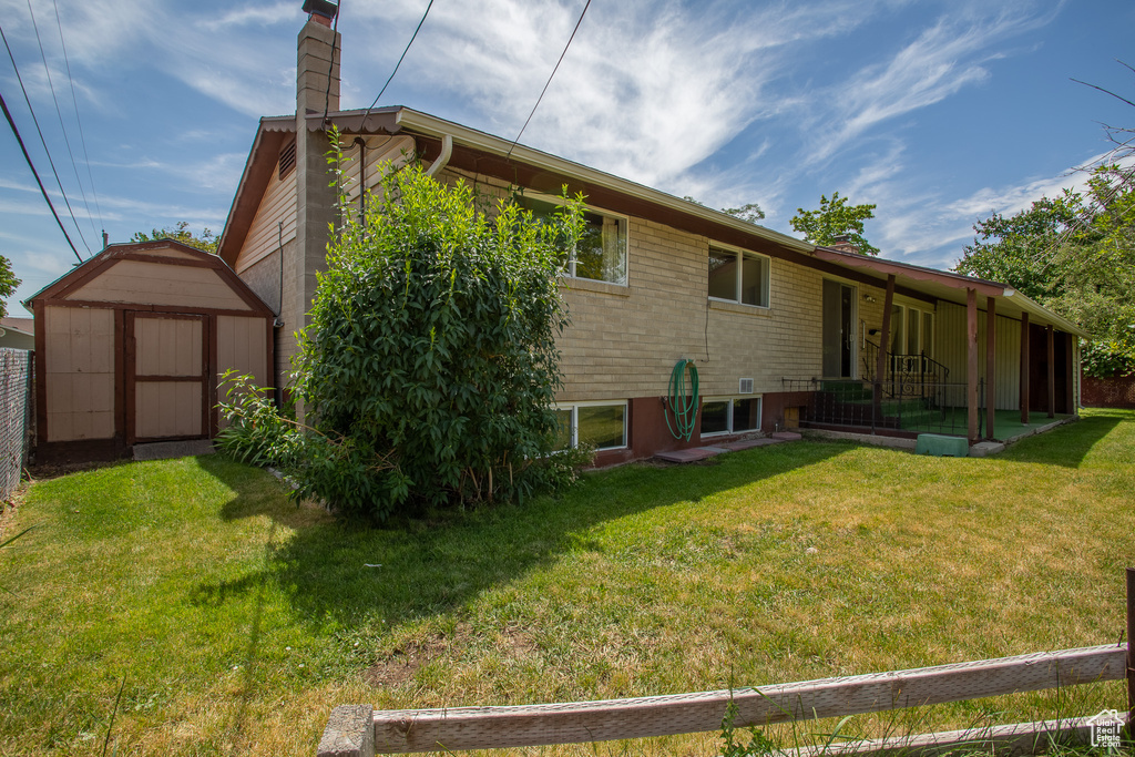 Rear view of property featuring a storage unit and a chimney