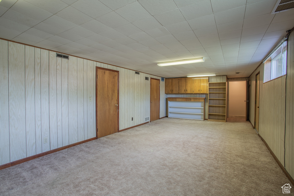 Below grade area with wood walls and light colored carpet