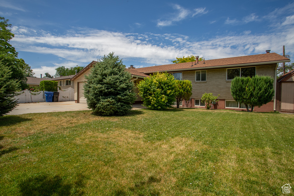 View of yard featuring concrete driveway and a garage