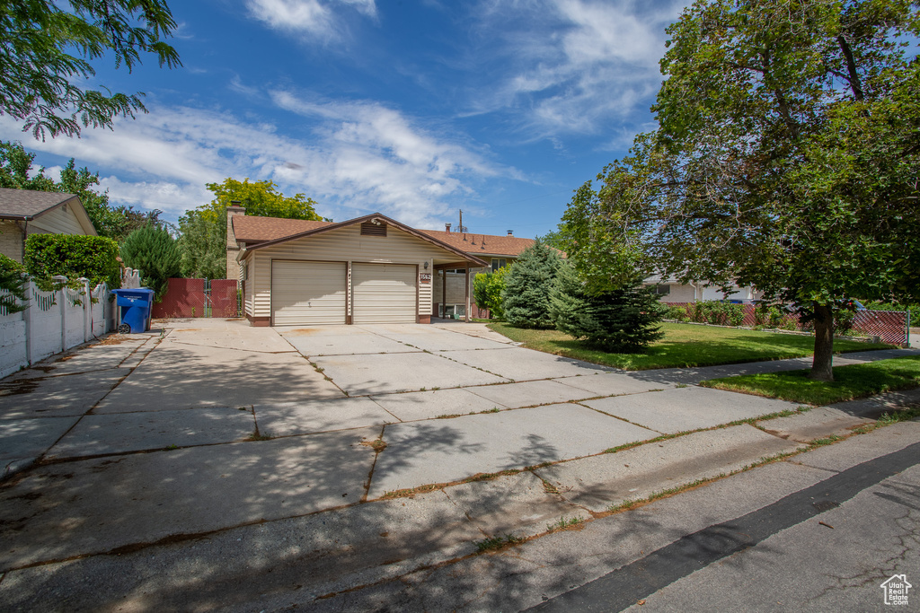 View of front of house with an attached garage, concrete driveway, and a chimney