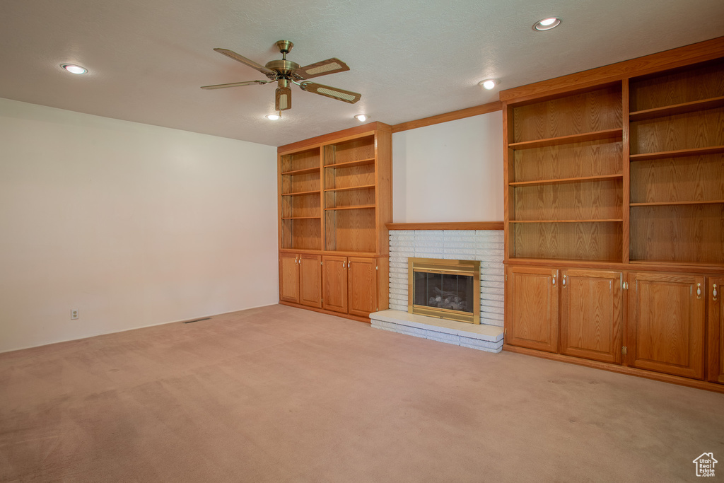 Unfurnished living room with light carpet, ceiling fan, a brick fireplace, and recessed lighting
