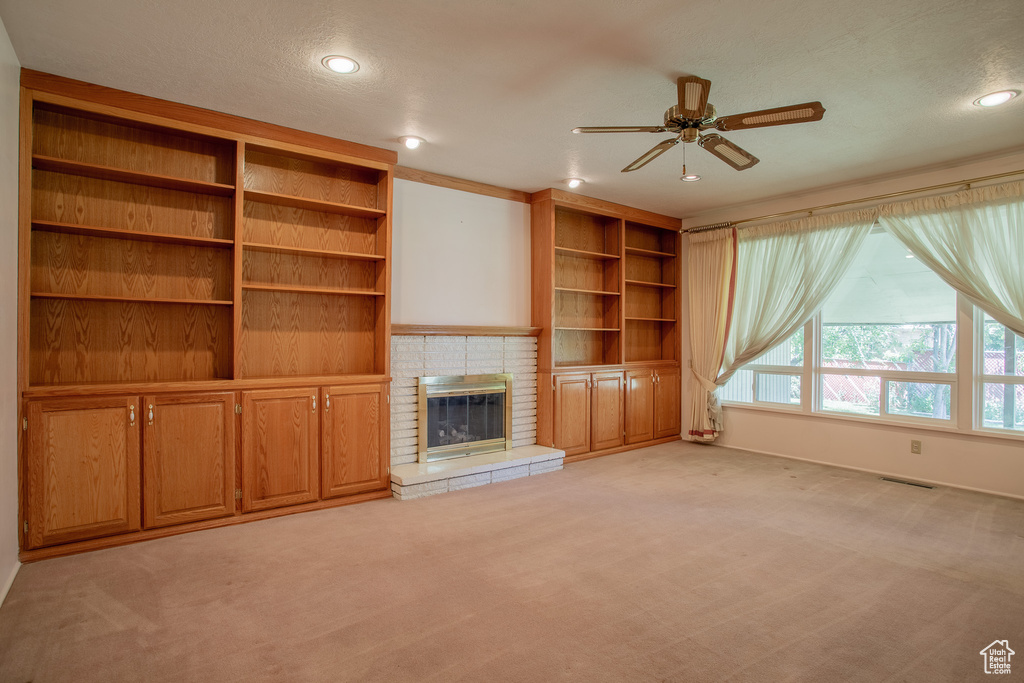 Unfurnished living room featuring ceiling fan, light carpet, recessed lighting, and a fireplace