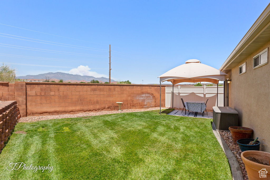 Fenced backyard featuring a mountain view