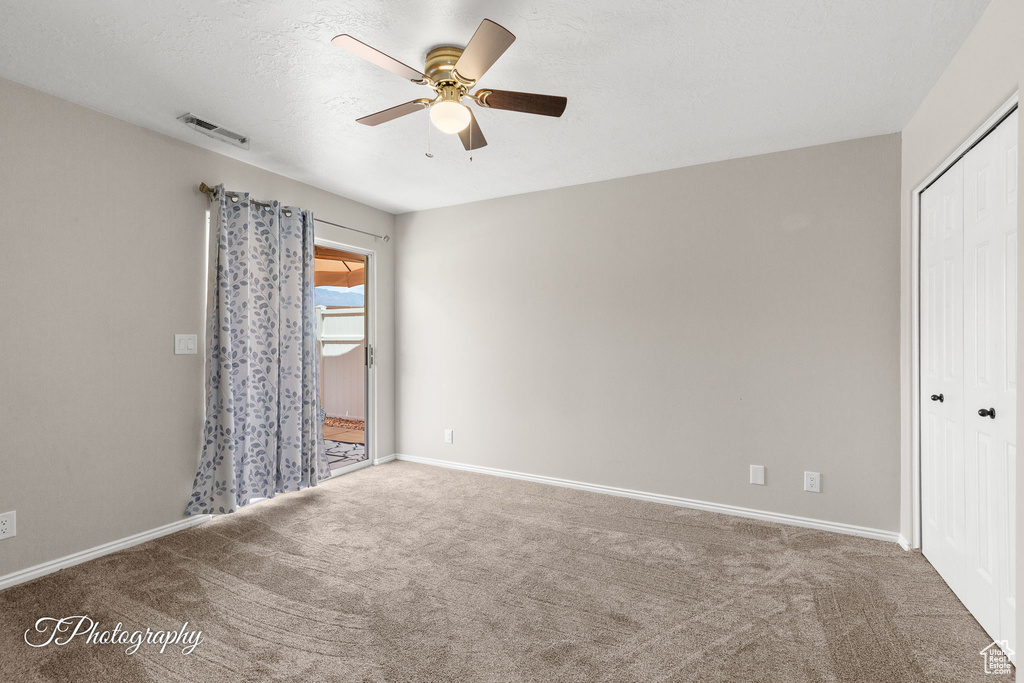 Spare room with ceiling fan and carpet floors