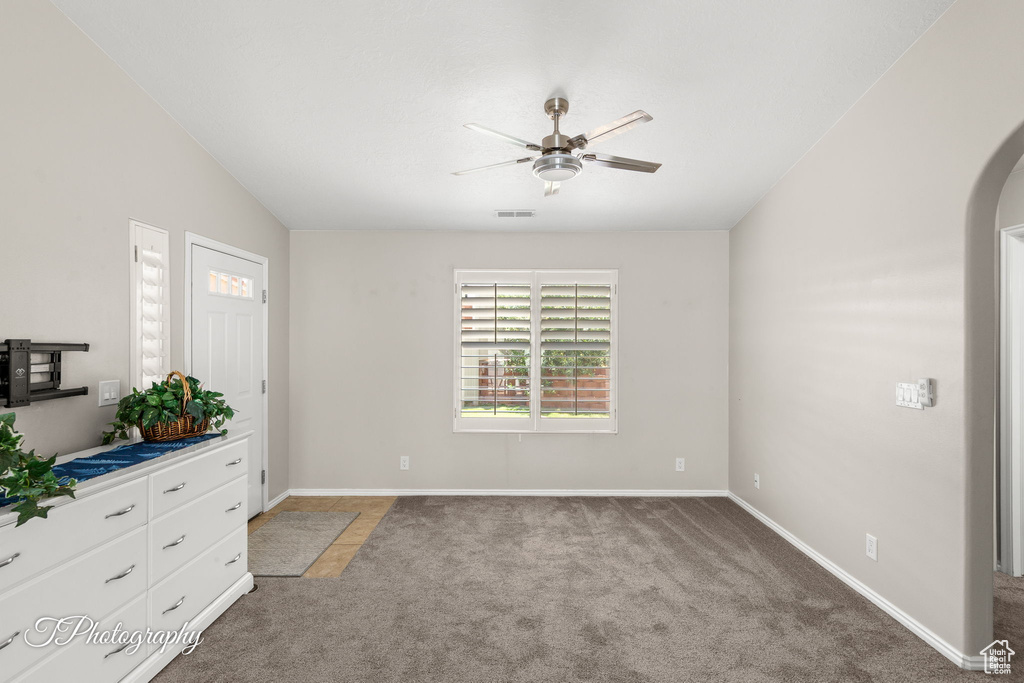 Unfurnished bedroom with light colored carpet, vaulted ceiling, and a ceiling fan