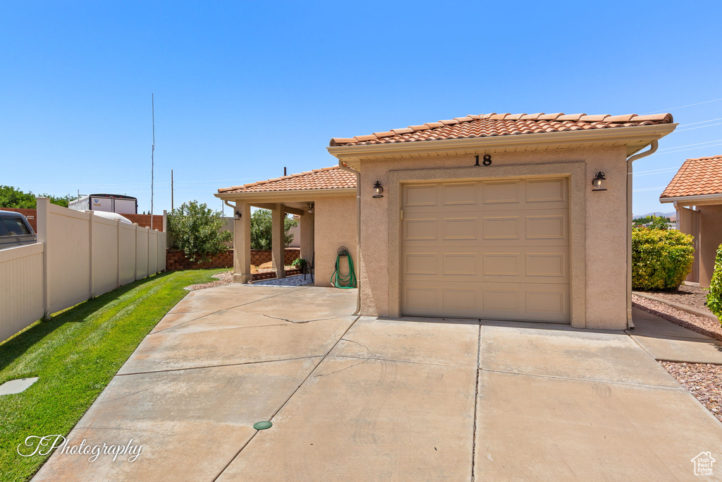 View of front facade with driveway, a tiled roof, and stucco siding