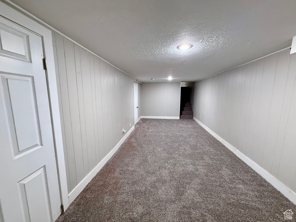 Finished below grade area featuring a textured ceiling and carpet
