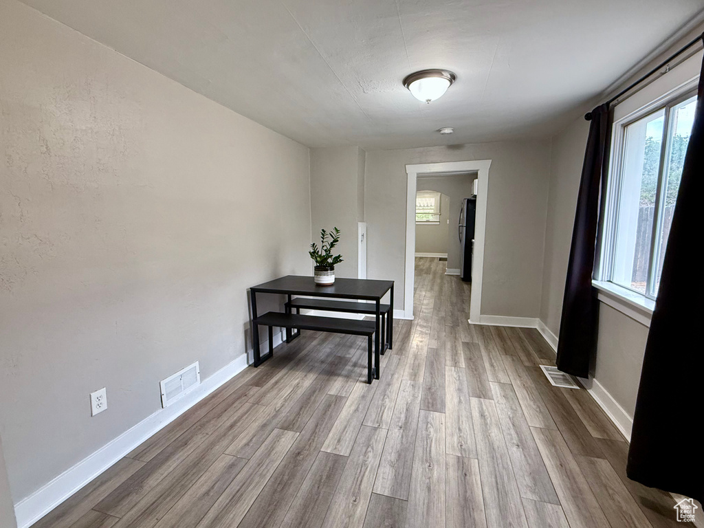 Hallway with healthy amount of natural light and wood finished floors