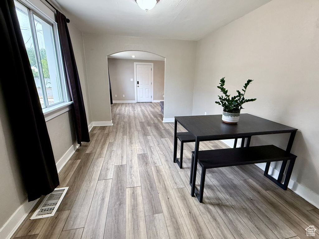 Hallway with arched walkways and wood finished floors