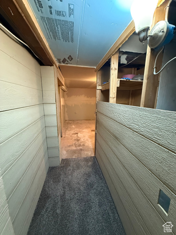 Hallway featuring carpet flooring and wood walls