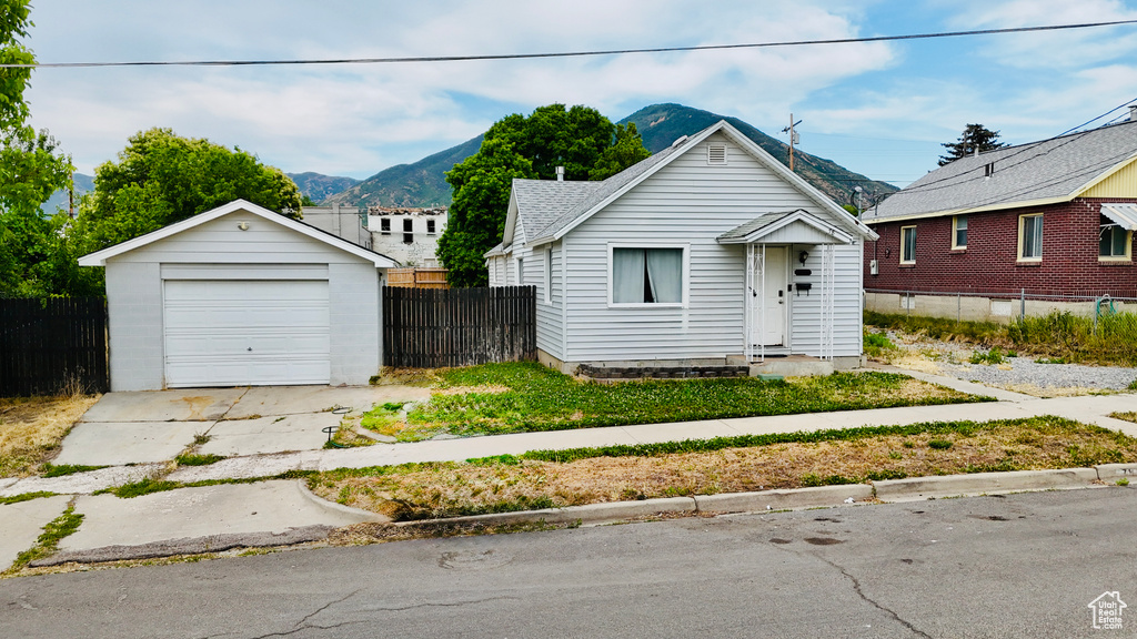 Bungalow-style house with an outbuilding, a garage, driveway, and a mountain view