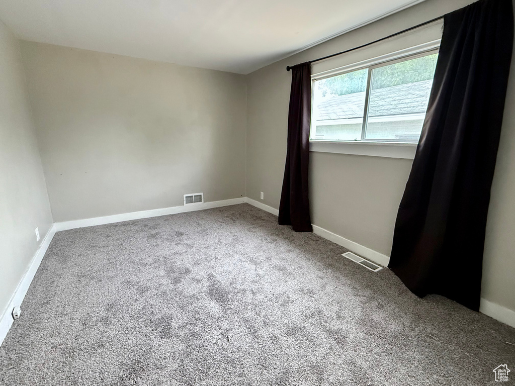 Carpeted empty room with baseboards