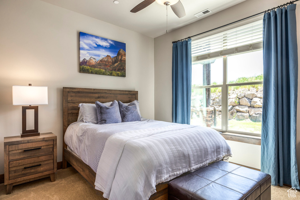 Bedroom with carpet, multiple windows, and ceiling fan