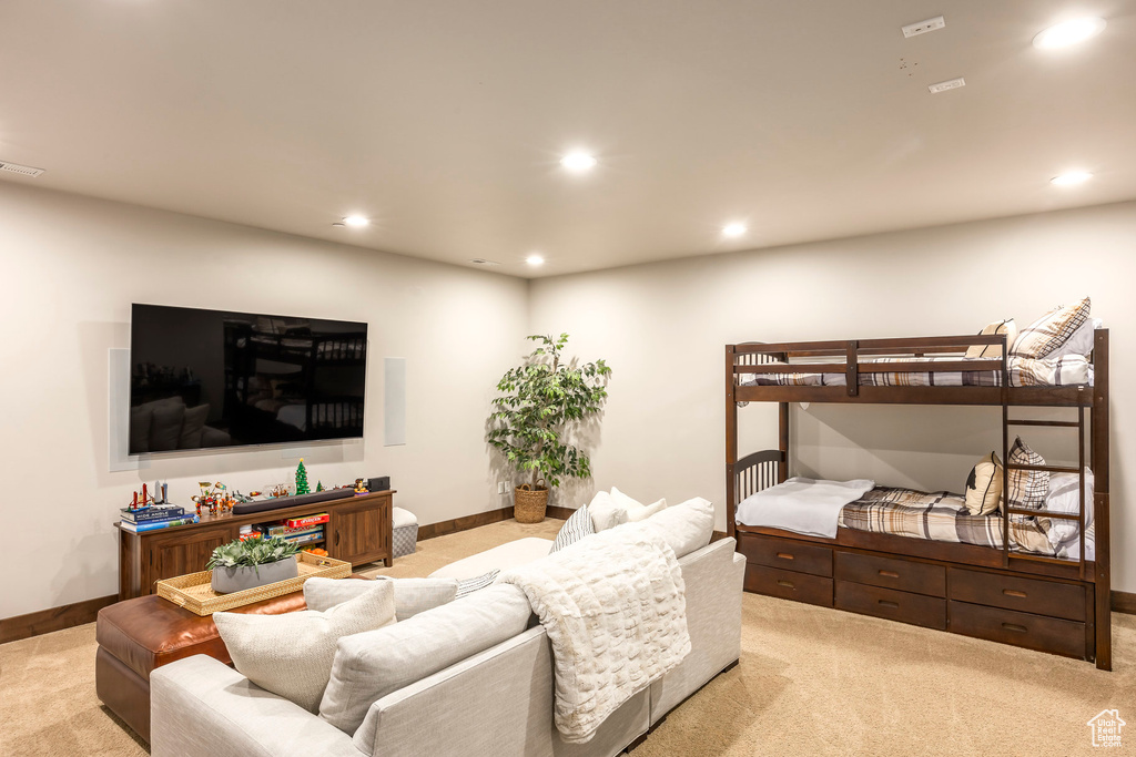 Living area with light colored carpet and recessed lighting