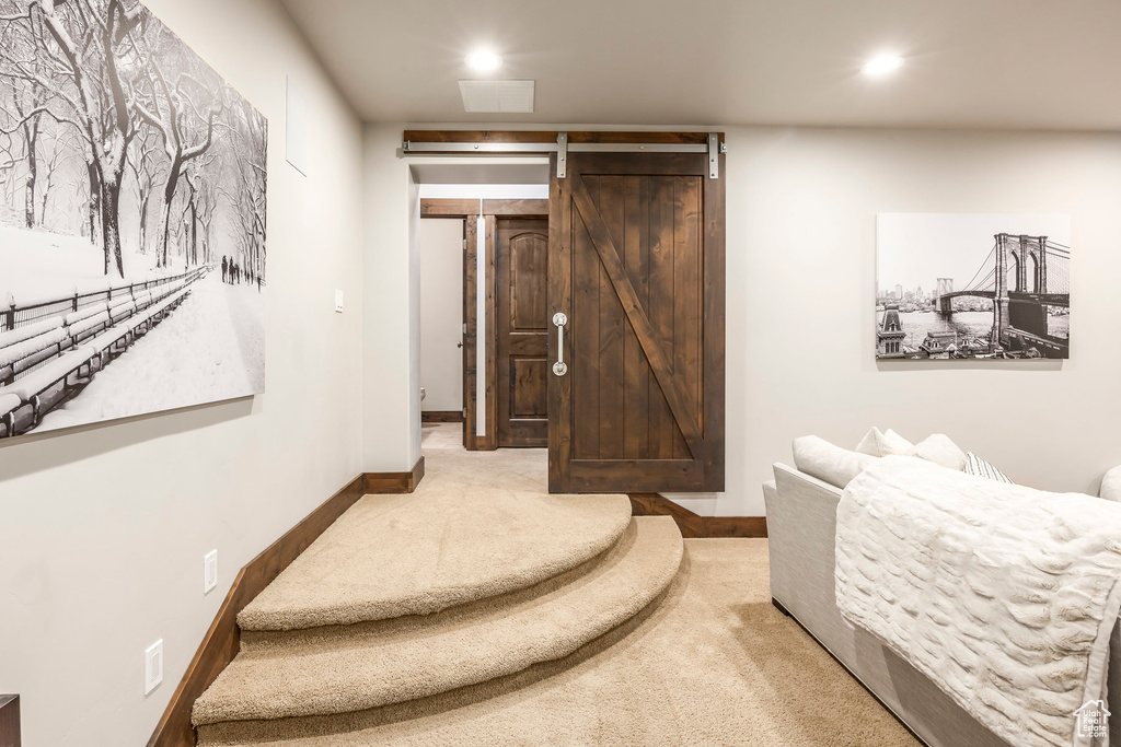 Bedroom with carpet floors, a barn door, and recessed lighting
