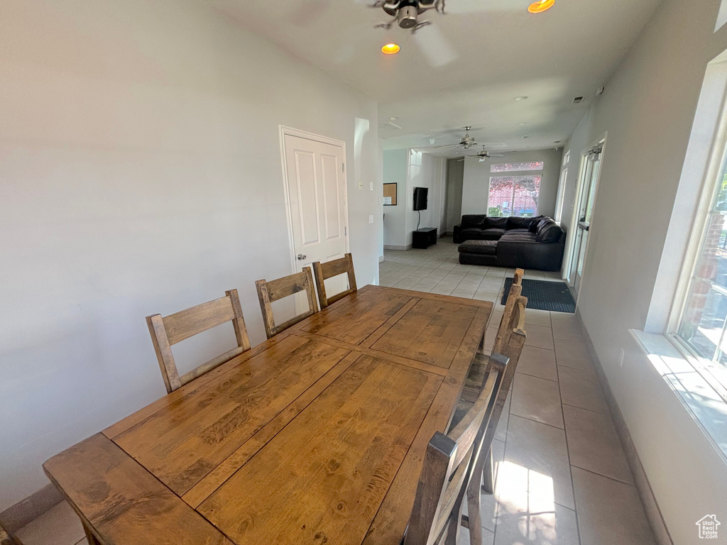 Tiled dining room with a ceiling fan and recessed lighting