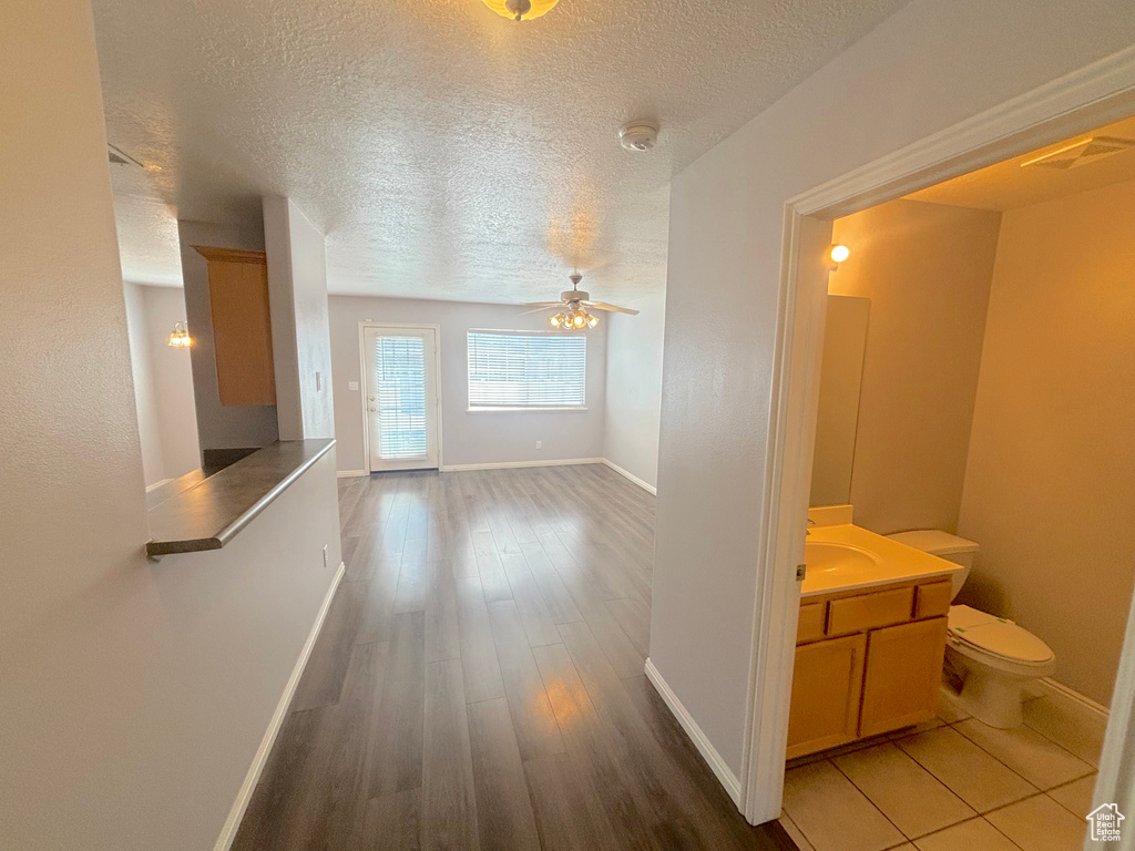 Corridor with a textured ceiling and wood finished floors