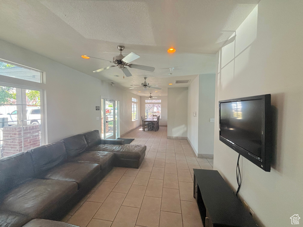 Living area with light tile patterned floors, ceiling fan, and recessed lighting