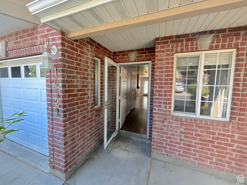 Property entrance with brick siding and an attached garage