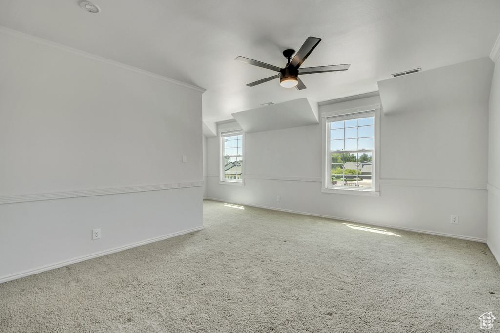 Carpeted spare room featuring a ceiling fan and baseboards