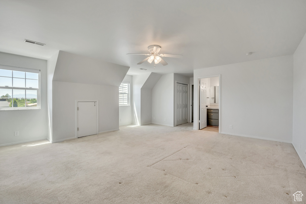 Additional living space featuring a ceiling fan and light carpet