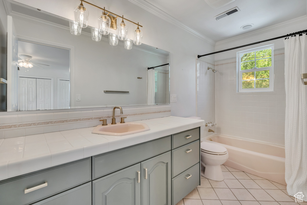 Bathroom with vanity, shower / bath combo with shower curtain, crown molding, and tile patterned flooring