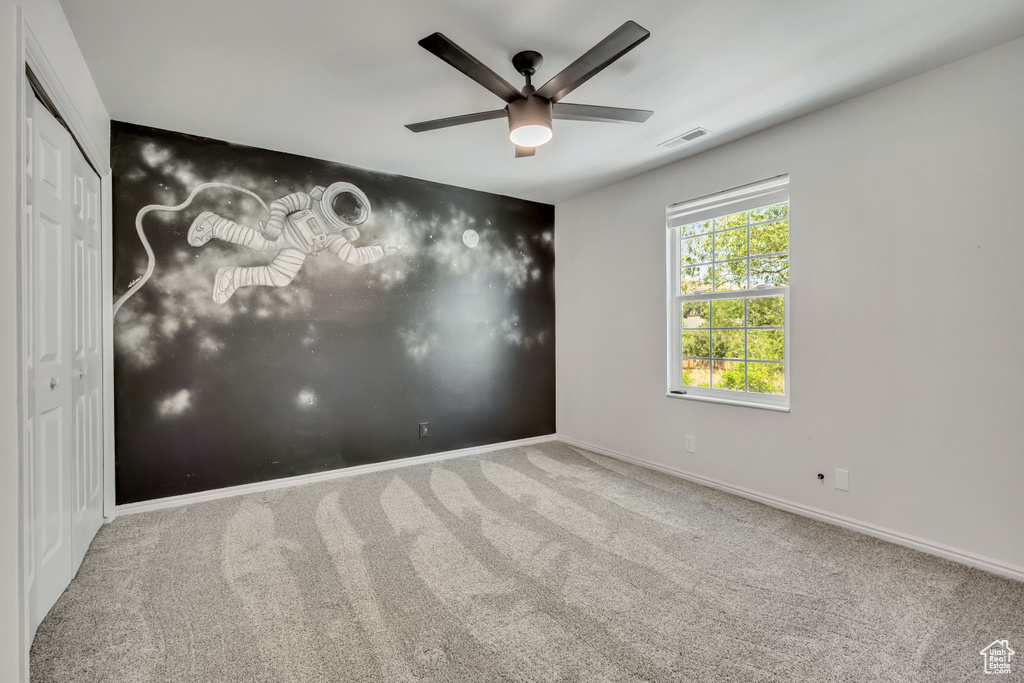Unfurnished room with carpet and ceiling fan