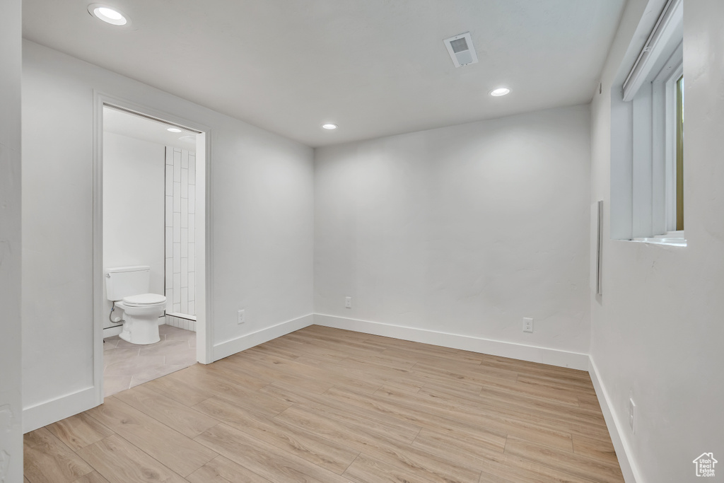 Unfurnished bedroom with light wood-style floors, recessed lighting, and connected bathroom