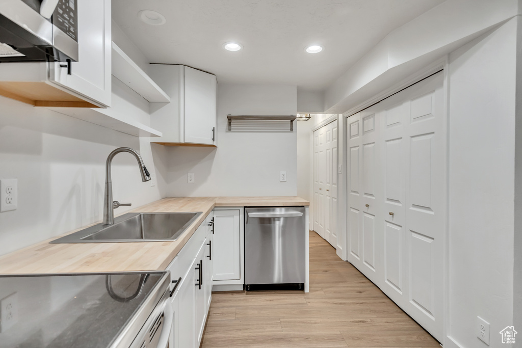 Kitchen with dishwasher, open shelves, wooden counters, recessed lighting, and white cabinets