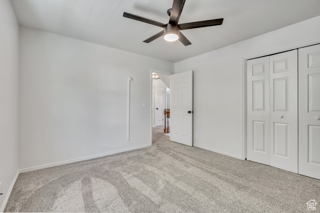 Unfurnished bedroom with carpet, a closet, and ceiling fan