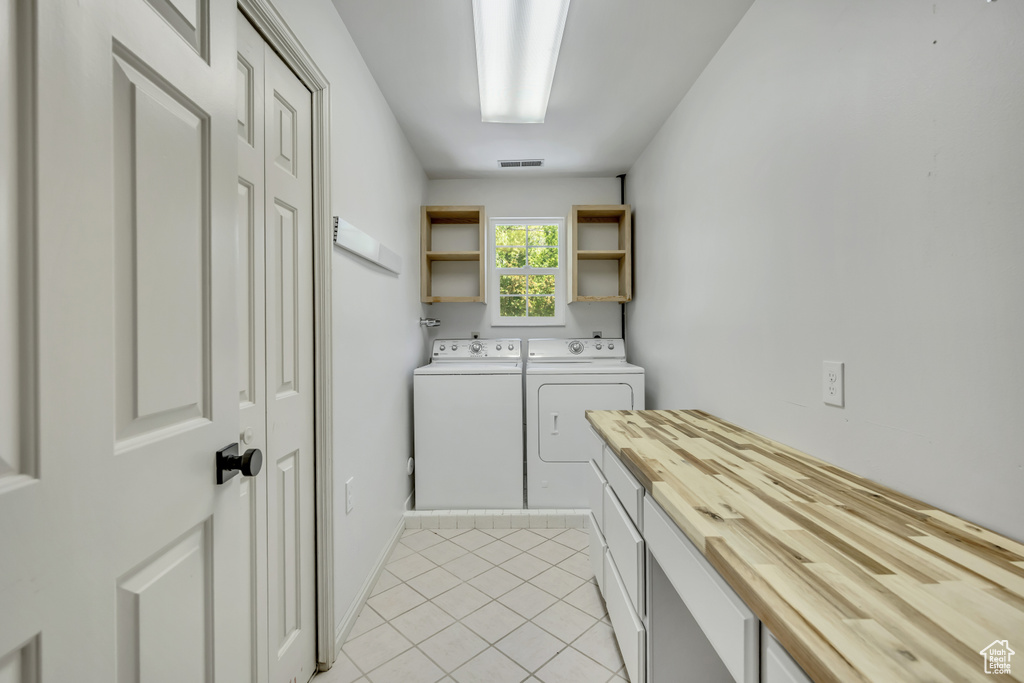 Laundry area featuring separate washer and dryer and light tile patterned floors