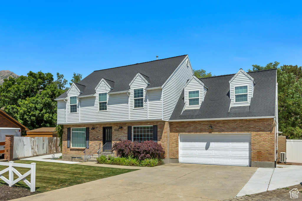 View of front of property with brick siding, driveway, a garage, and a shingled roof